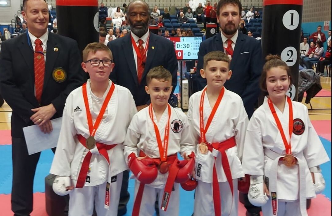 Junior members with their medals beside the officials at a championship