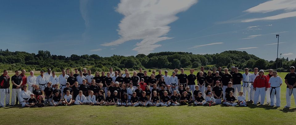 The whole club, juniors and seniors, together on a field for a summer course